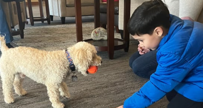 Pet therapy volunteer playing with young boy